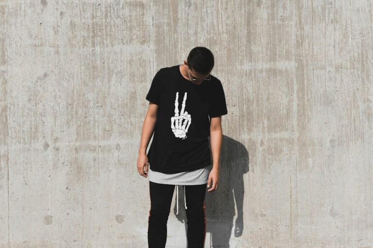 Man wearing a black graphic T-shirt with dark trousers