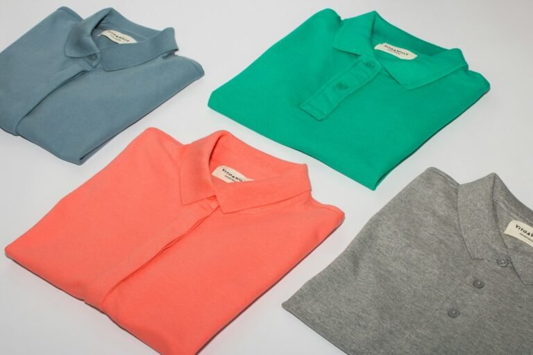 Folded polo shirts in grey, green, coral and white