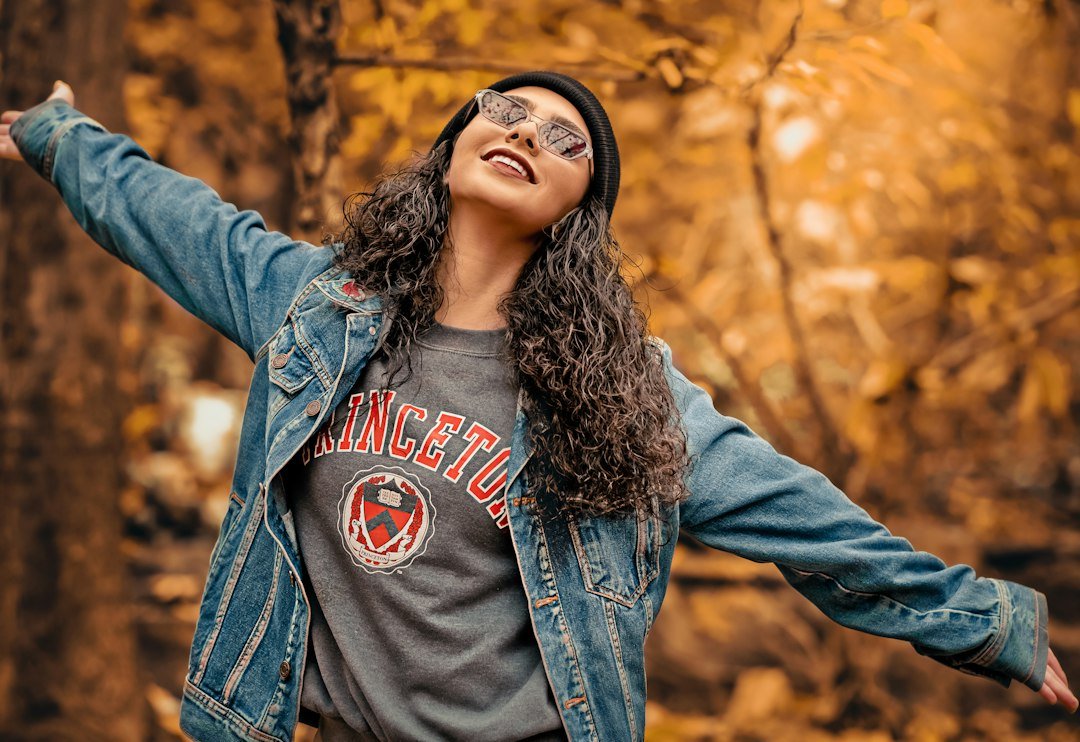Denim jacket over a graphic tee in an outdoor setting